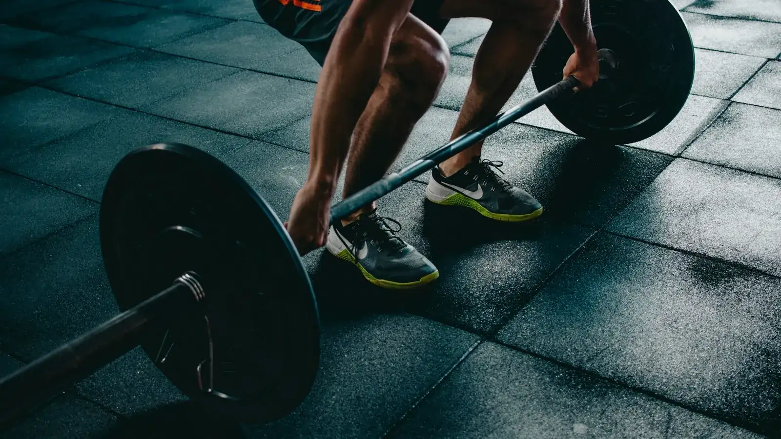 Persona levantando una barra con discos en un gimnasio